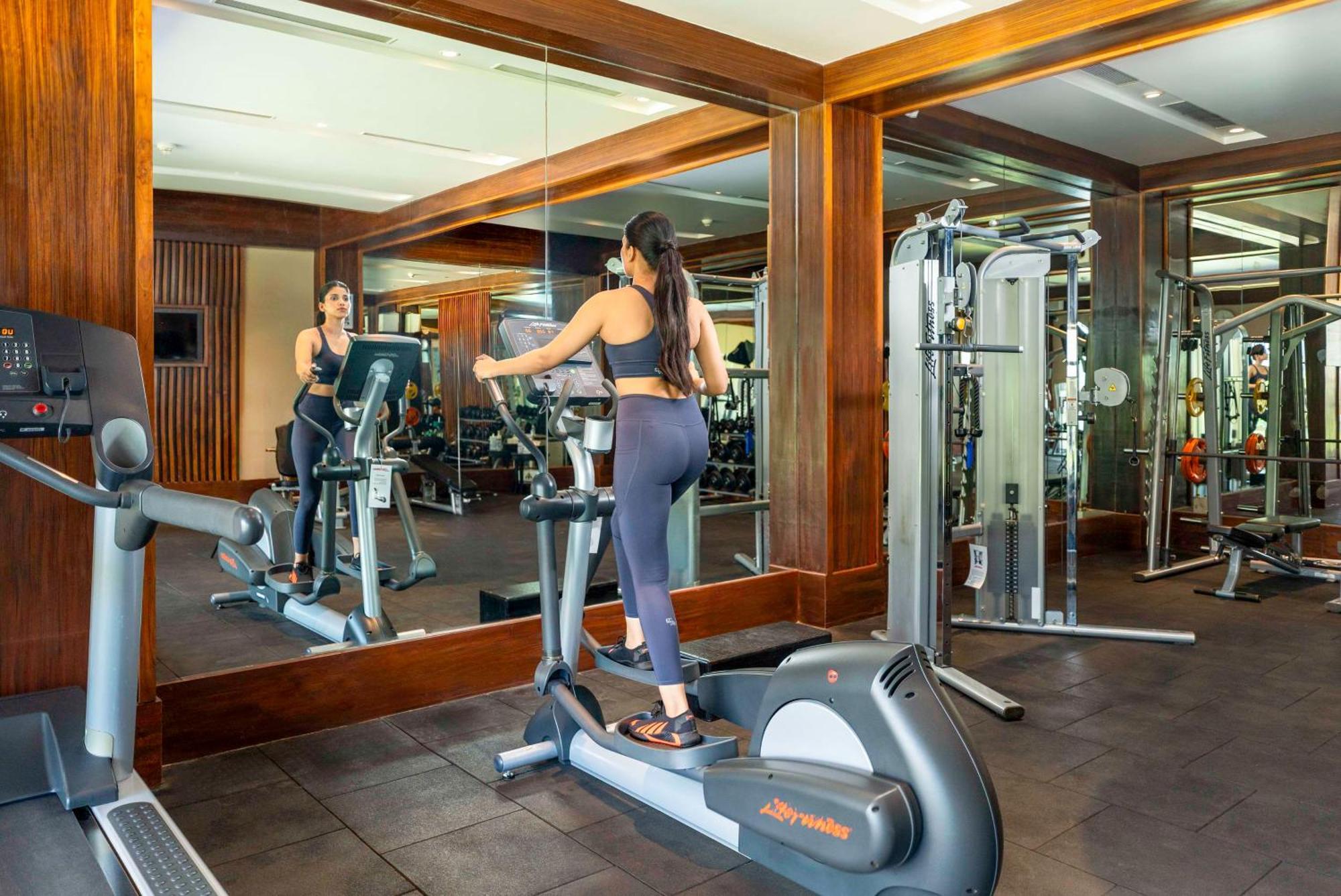 Radisson Blu Plaza Resort & Convention Centre Karjat Exteriér fotografie A woman on an elliptical trainer